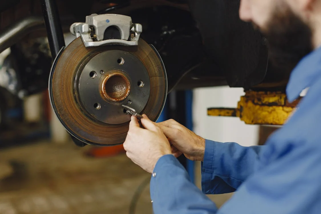 Mechanic performing brake repair service in Dallas at Pit Pros Automotive