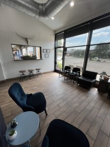 Home 8 Pit Pros Automotive reception area and waiting room with chairs and large windows.