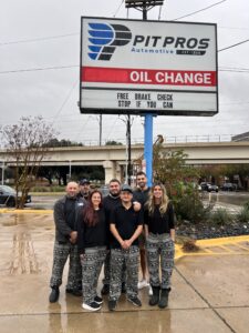 Home 2 Pit Pros Automotive team standing outside the Dallas shop under the Pit Pros sign.
